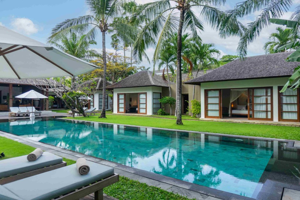 Villa Tiga Puluh, a modern tropical villa featuring a private pool, open-air living spaces, lush gardens, and Balinese-inspired architecture for a relaxing stay.