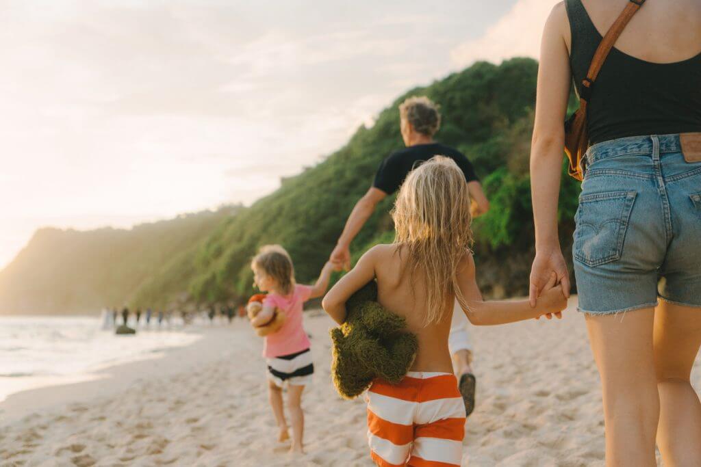 family walking on the beach while holidaying