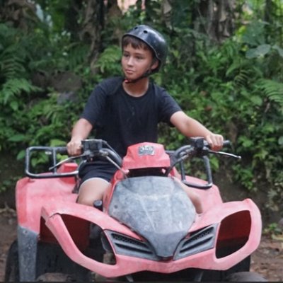 People riding ATVs through lush tropical trails in Bali, enjoying an adventurous outdoor activity with dirt tracks and scenic landscapes.