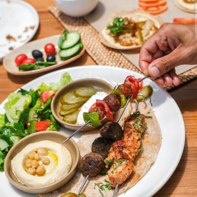 Zali Cafe in Bali featuring cozy outdoor seating, tropical plants, wooden decor, and guests enjoying coffee and healthy meals in a relaxed atmosphere.