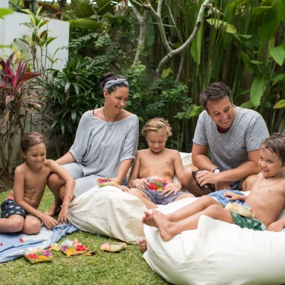 Professional family photoshoot in a private villa, showing a family enjoying outdoor spaces, a pool, and tropical surroundings with natural lighting.