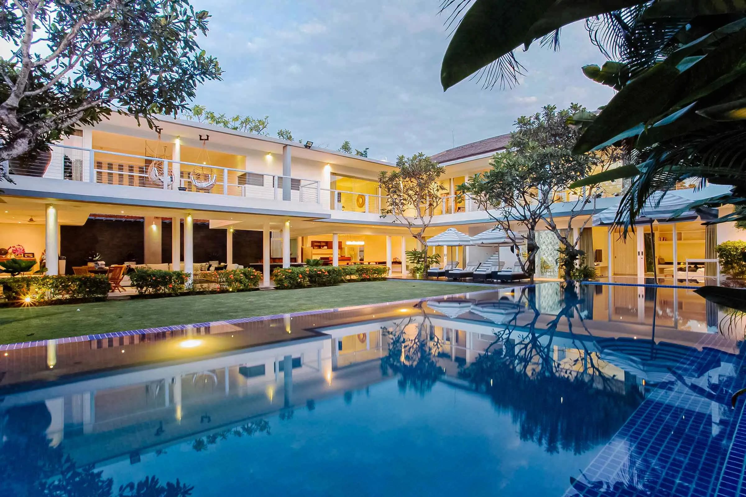 Elegant tropical villa named Villa Cassa Mia, featuring a modern open-plan design, large private pool, sun loungers, and lush garden surroundings