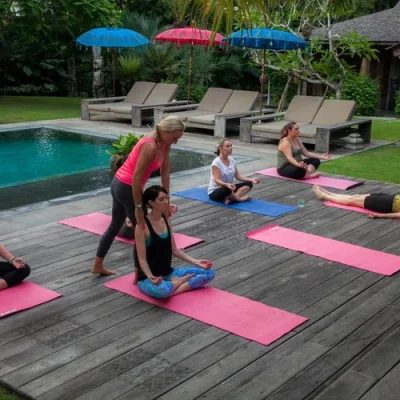 People practicing yoga and meditation in a serene tropical setting, surrounded by greenery, promoting relaxation, mindfulness, and wellness.
