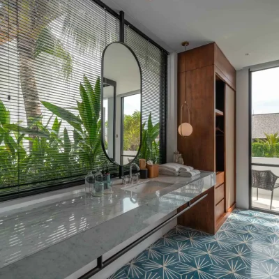 Mandala Oasis Villa A luxurious tropical villa named Mandala Oasis Villa, featuring an infinity pool surrounded by palm trees, lush gardens, and modern open-air architecture under a bright blue sky.